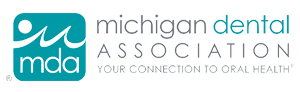 The image shows a logo with text that reads  MICHIGAN DENTAL ASSOCIATION  and includes a graphic of a stylized tooth and a fish, suggesting an association related to dental care and possibly aquatic life or marine environment.
